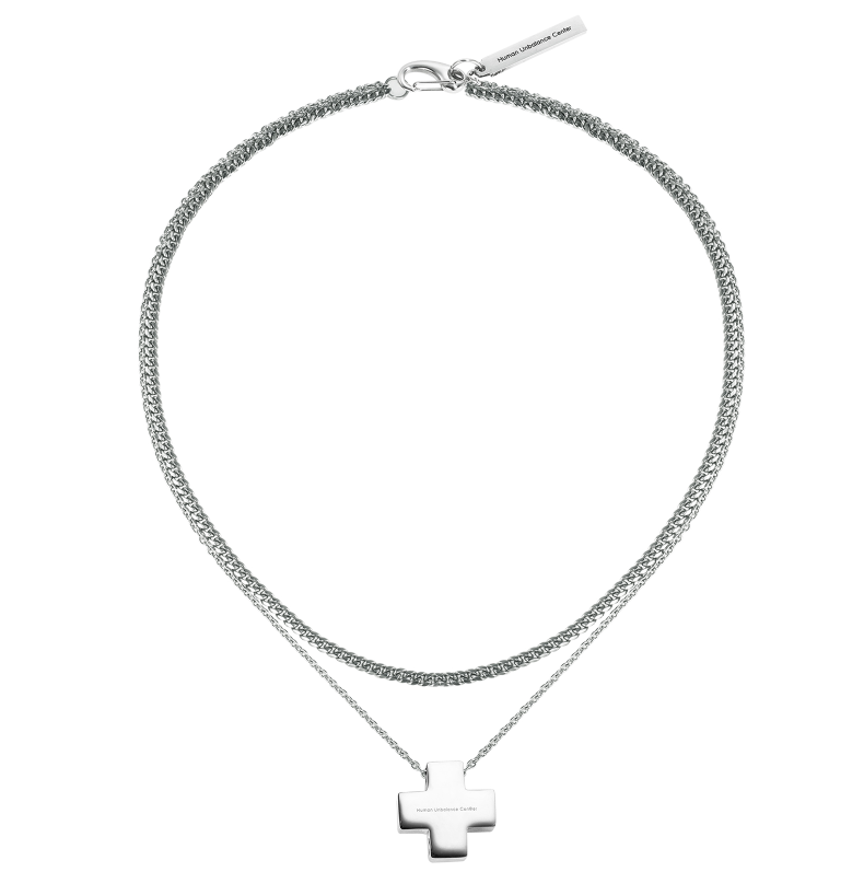 Silver-tone layered necklace with a heavy woven chain and a fine strand holding a squared cross pendant.