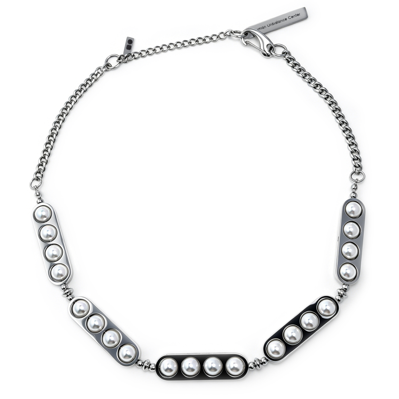 Curb-chain necklace with articulated bar plates set with rows of pearls in silver and dark tones.